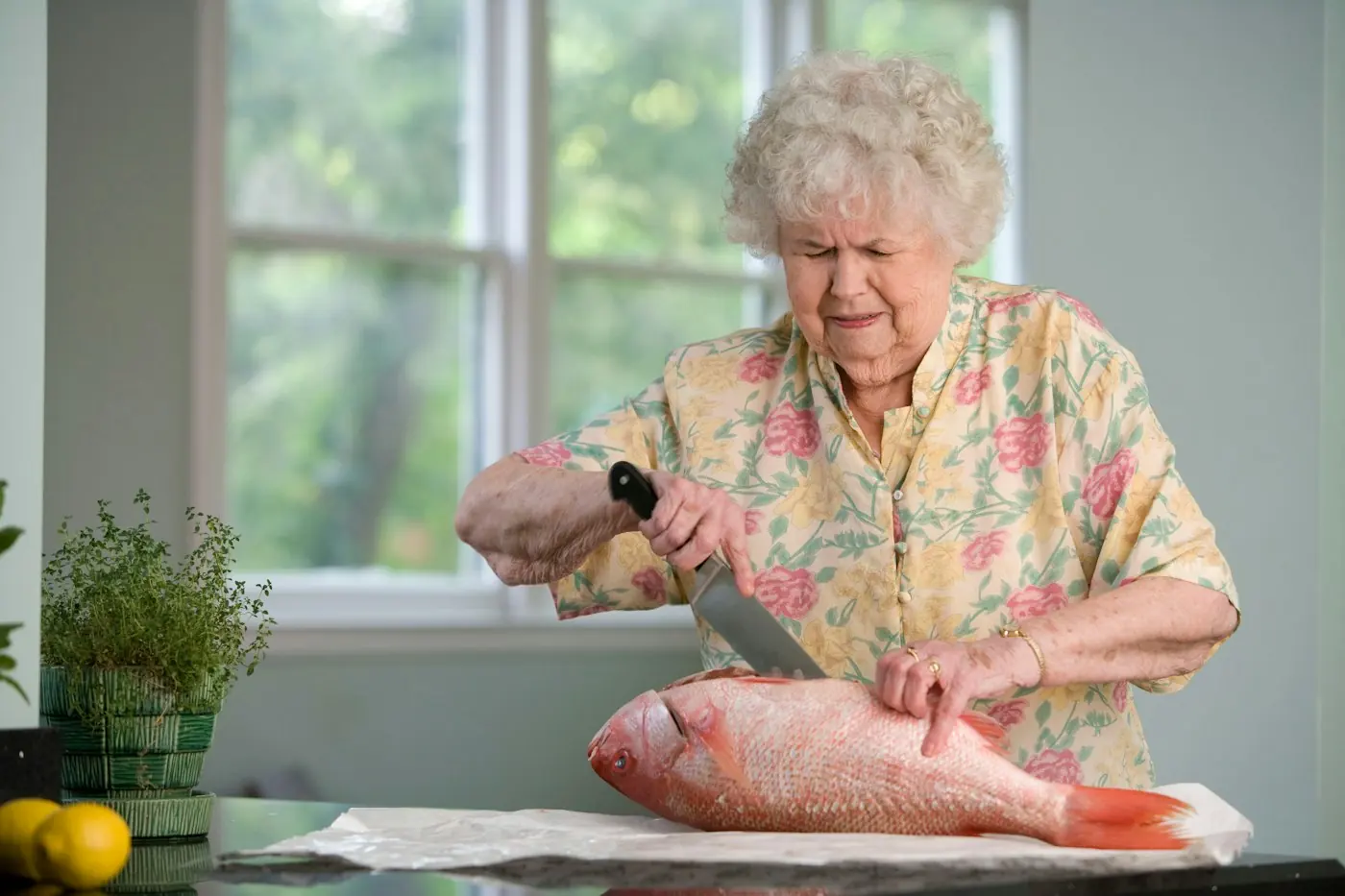 A caregiver holding an older adult’s hands during a home visit.